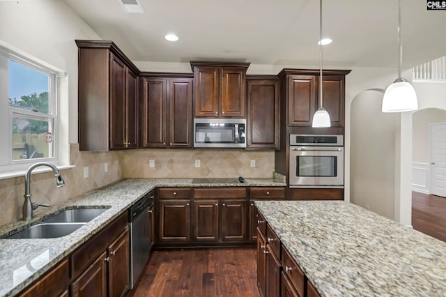 kitchen featuring tasteful backsplash, sink, dark hardwood / wood-style flooring, hanging light fixtures, and stainless steel appliances