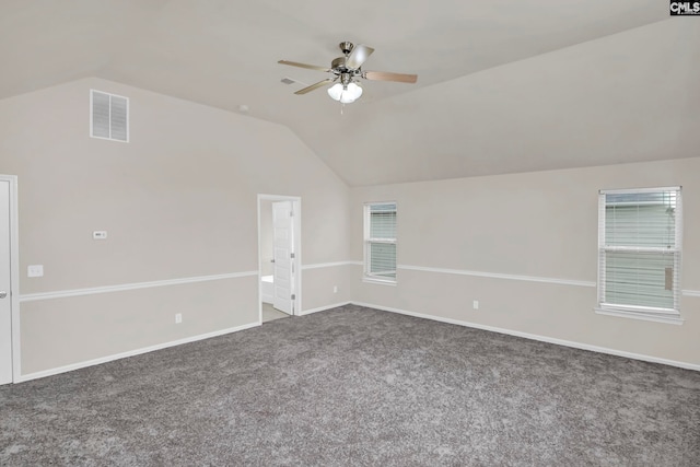 carpeted spare room featuring ceiling fan and vaulted ceiling