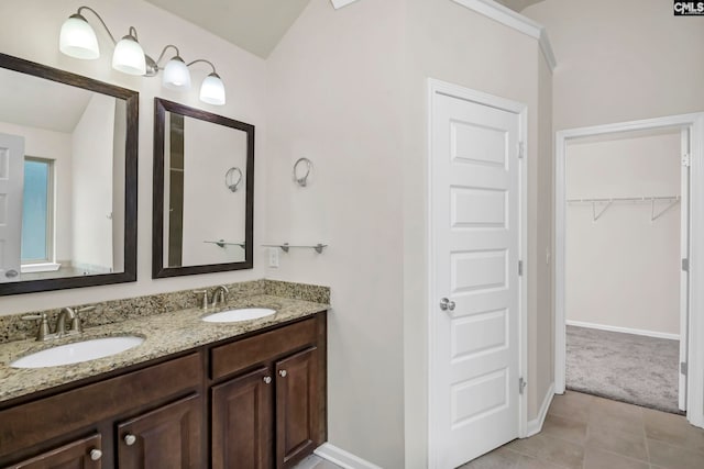 bathroom featuring vanity, tile patterned flooring, and vaulted ceiling