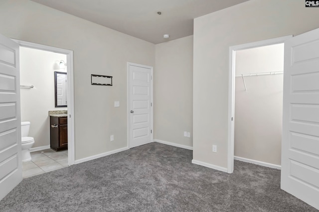 unfurnished bedroom with connected bathroom and light carpet