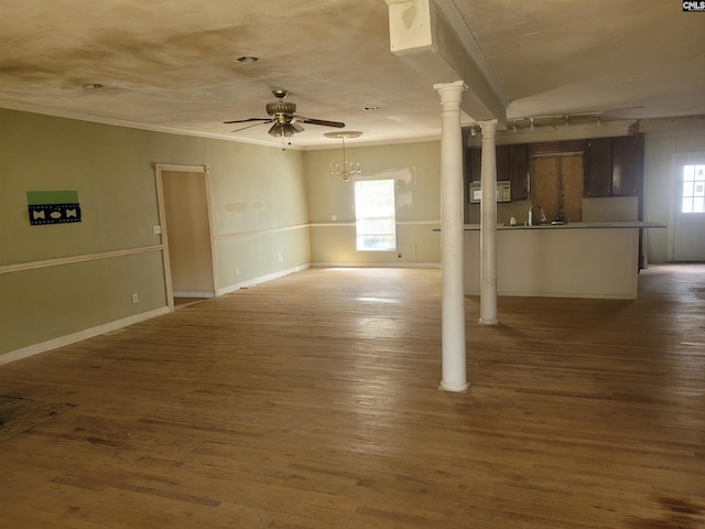 unfurnished living room featuring dark hardwood / wood-style floors, a healthy amount of sunlight, and ceiling fan with notable chandelier