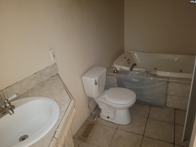 bathroom with toilet, a relaxing tiled tub, tile patterned floors, and sink