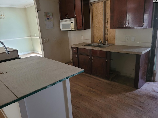 kitchen featuring dark brown cabinets, sink, and dark wood-type flooring