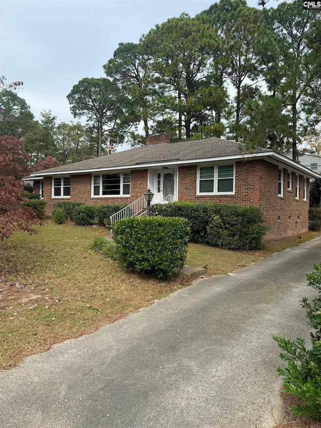 ranch-style home featuring a front lawn