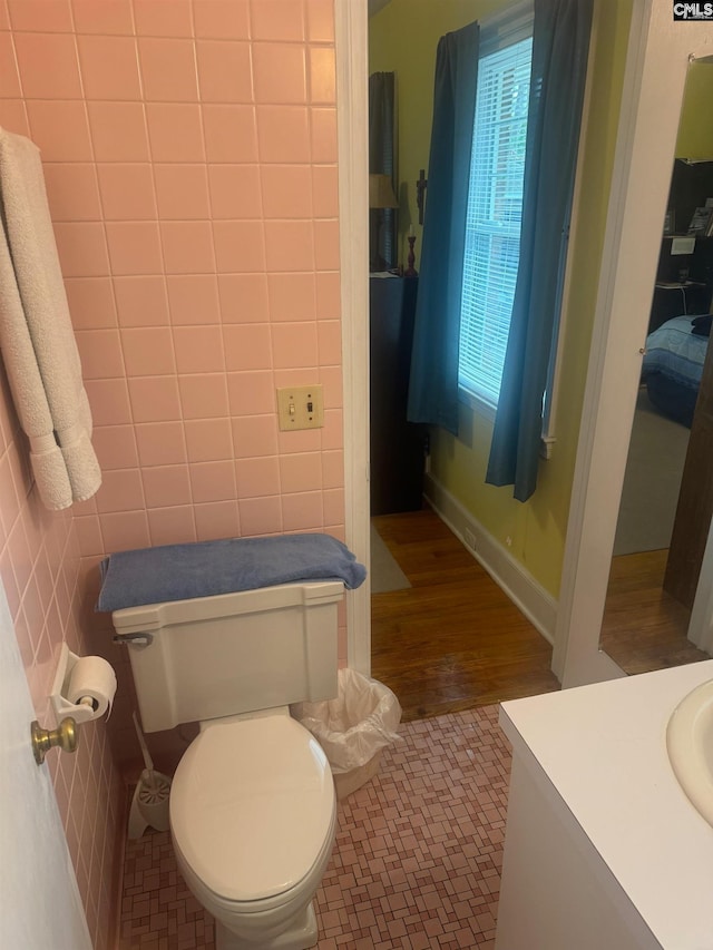 bathroom featuring tile walls, vanity, hardwood / wood-style flooring, and toilet