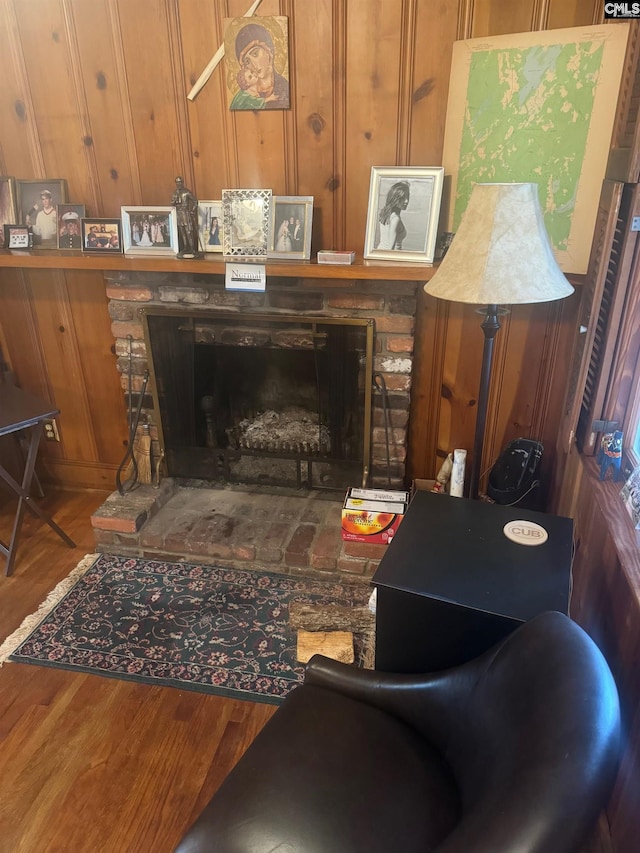 living room featuring a stone fireplace and wood-type flooring