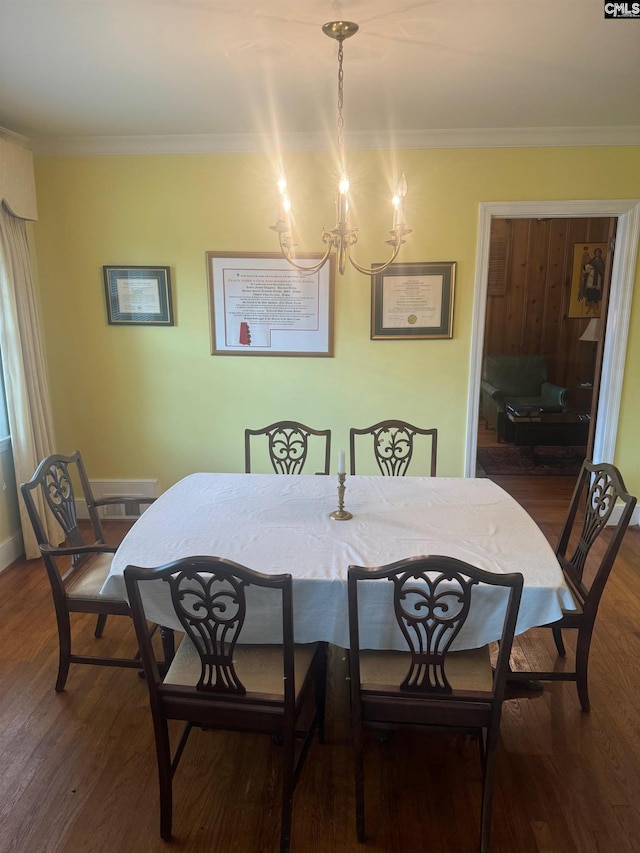 dining room featuring crown molding, an inviting chandelier, and dark hardwood / wood-style flooring