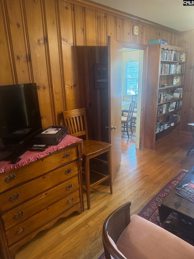 interior space with light hardwood / wood-style floors and wooden walls