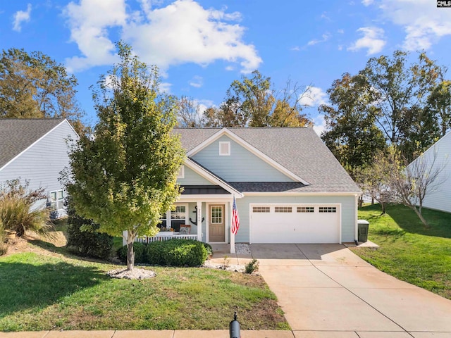 view of front of home with a garage, a front lawn, and a porch