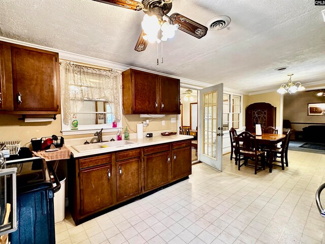 kitchen featuring a textured ceiling, ornamental molding, pendant lighting, sink, and electric range oven