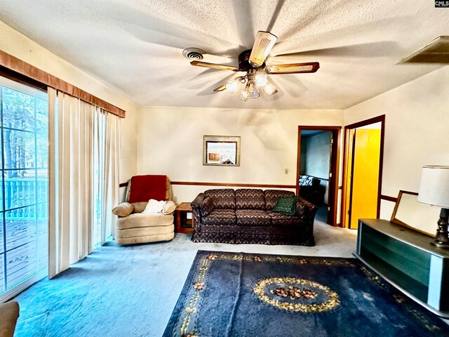 carpeted living room featuring a textured ceiling and ceiling fan