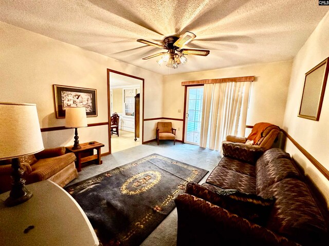 living room featuring a textured ceiling and ceiling fan