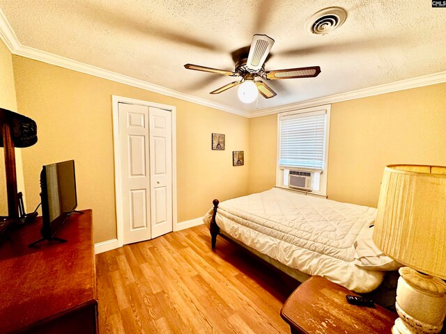 bedroom with ceiling fan, hardwood / wood-style flooring, a textured ceiling, and crown molding