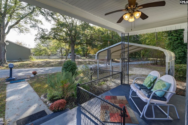 view of patio / terrace with ceiling fan and a carport