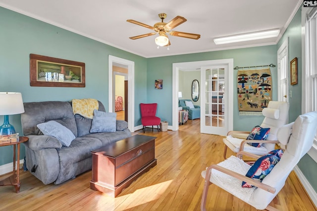 living room with ornamental molding, french doors, light hardwood / wood-style floors, and ceiling fan