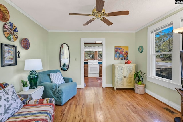 sitting room featuring crown molding, light wood-type flooring, and ceiling fan