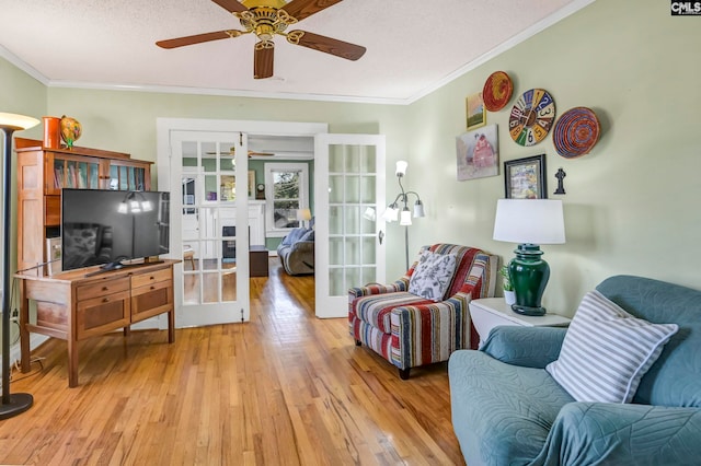 sitting room featuring light hardwood / wood-style flooring, french doors, ceiling fan, and crown molding