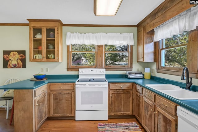 kitchen with white appliances, sink, kitchen peninsula, ornamental molding, and light hardwood / wood-style flooring