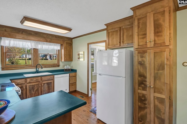 kitchen with light hardwood / wood-style flooring, sink, crown molding, a textured ceiling, and white appliances