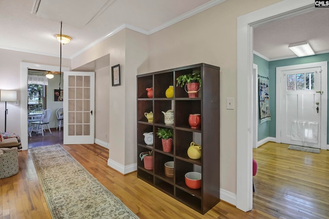 hall featuring french doors, crown molding, and wood-type flooring