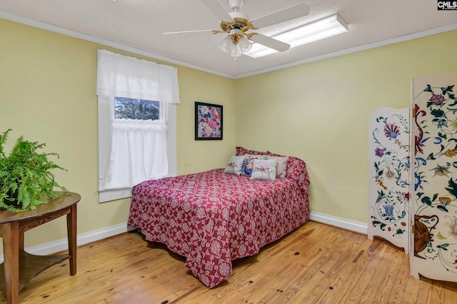 bedroom with ceiling fan, crown molding, and light hardwood / wood-style floors