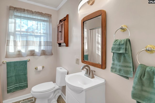 bathroom with vanity, toilet, and ornamental molding