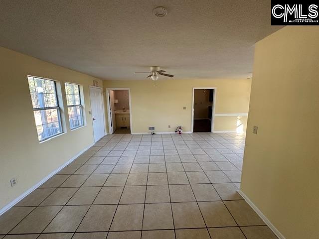 tiled empty room with a textured ceiling and ceiling fan