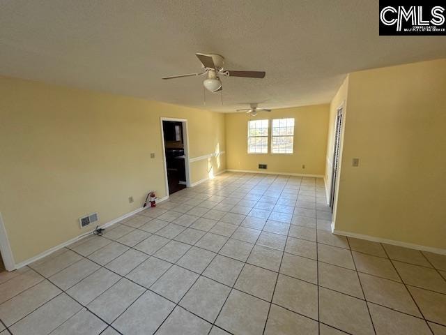 unfurnished room with ceiling fan and light tile patterned floors