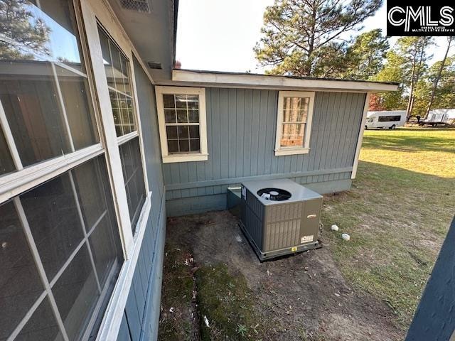 exterior space with central air condition unit and a yard