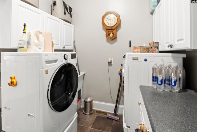 laundry area with washer / dryer, dark tile patterned flooring, and cabinets