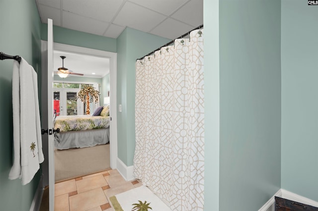 bathroom with a drop ceiling, tile patterned flooring, and ceiling fan