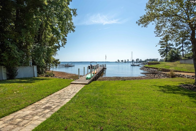 dock area with a lawn and a water view