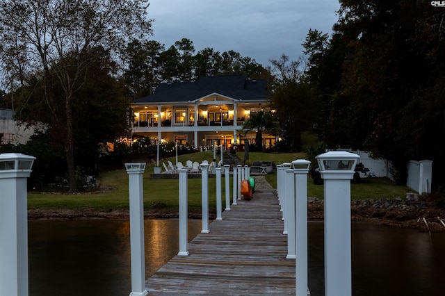 dock area featuring a water view and a lawn