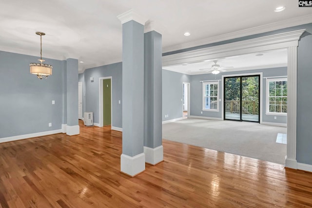 unfurnished living room with hardwood / wood-style flooring, ornamental molding, and ceiling fan with notable chandelier