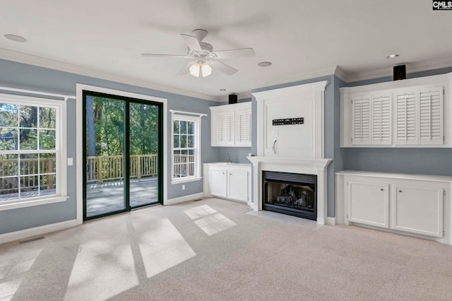 unfurnished living room with crown molding, a fireplace, light colored carpet, and ceiling fan