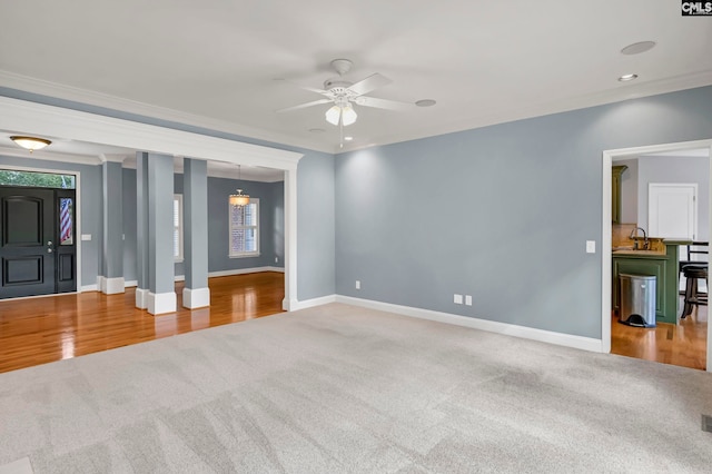 unfurnished living room with ceiling fan, hardwood / wood-style flooring, and ornamental molding