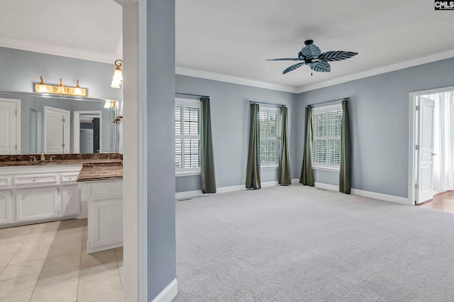 interior space with ornamental molding, sink, light carpet, and ceiling fan