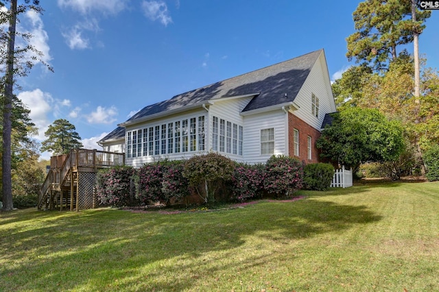 view of property exterior with a wooden deck and a yard