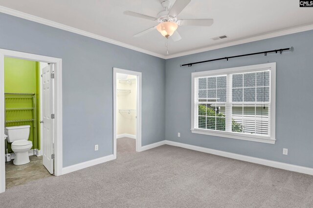 unfurnished bedroom featuring light carpet, a spacious closet, and connected bathroom