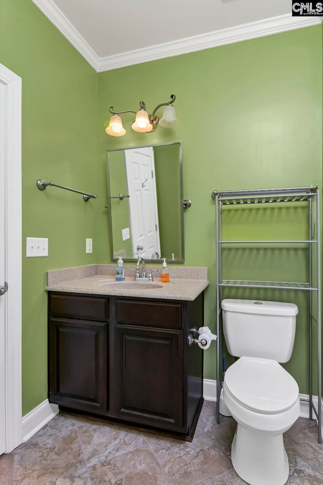 bathroom with vanity, ornamental molding, and toilet