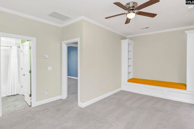 empty room with crown molding, light colored carpet, and ceiling fan