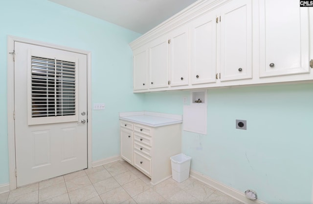 washroom with light tile patterned flooring, electric dryer hookup, washer hookup, and cabinets