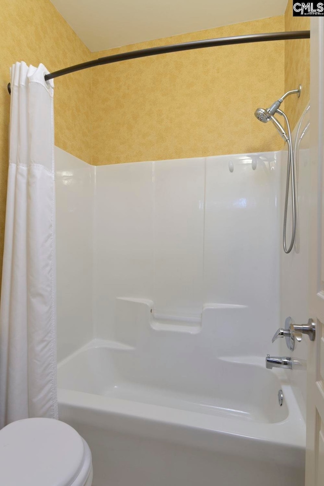 bathroom featuring toilet and shower / tub combo