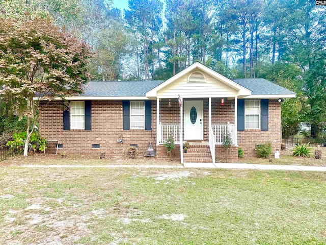 ranch-style home featuring a front lawn and covered porch