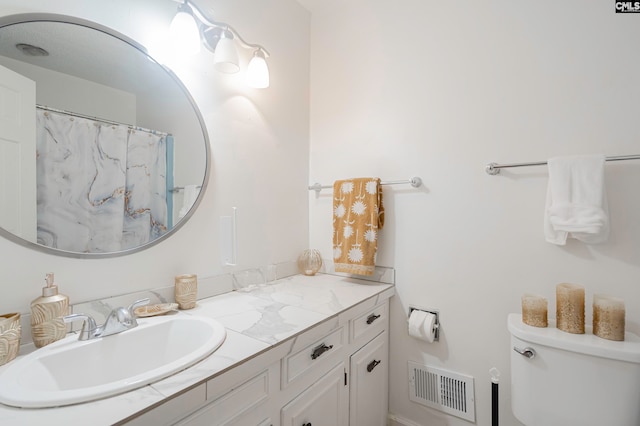 bathroom featuring vanity, toilet, and a shower with shower curtain