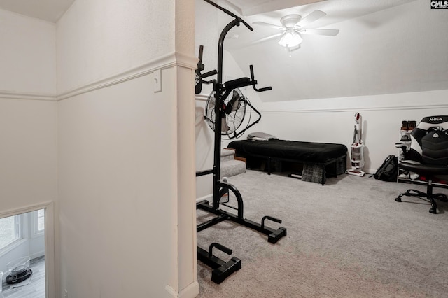 exercise room with carpet flooring, vaulted ceiling, and ceiling fan