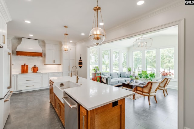 kitchen featuring sink, hanging light fixtures, a center island with sink, stainless steel dishwasher, and white cabinets