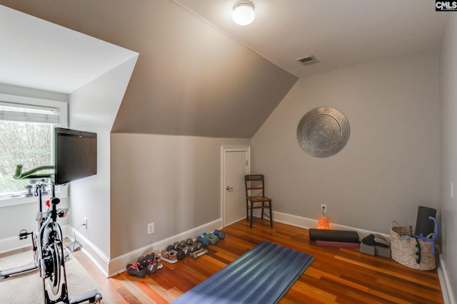 workout area with lofted ceiling and dark wood-type flooring