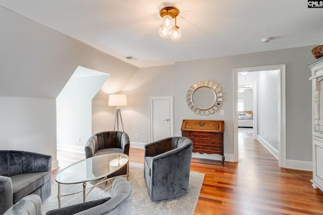 sitting room featuring hardwood / wood-style flooring and lofted ceiling