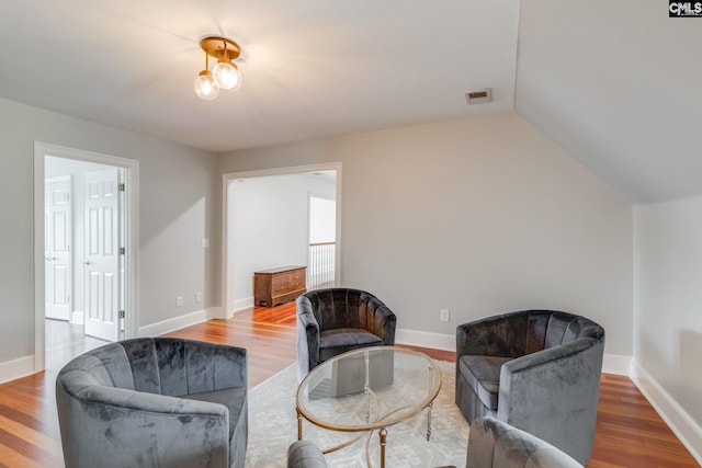 living area featuring vaulted ceiling and hardwood / wood-style floors